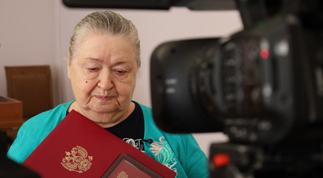 Мать одного из бойцов с наградой сына. Скриншот фото администрации Тахтамукайского района от 20.08.25, https://t.me/tahtamukay/11446.