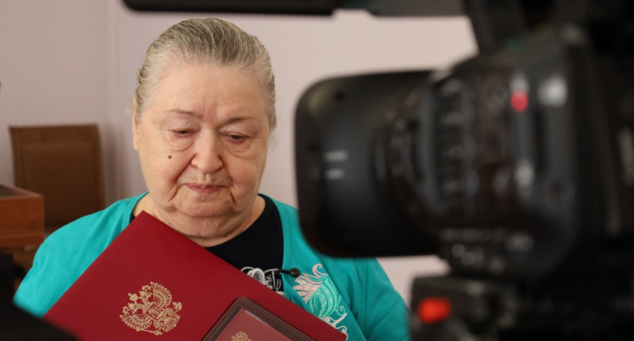 Мать одного из бойцов с наградой сына. Скриншот фото администрации Тахтамукайского района от 20.08.25, https://t.me/tahtamukay/11446.