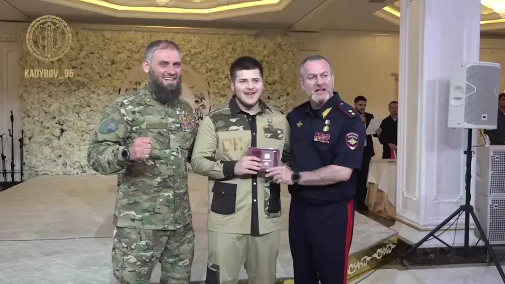 Адам Кадыров (в центре) во время получения медали "Защитнику Чечни". Скриншот видео Телеграм-канал Kadyrov_95