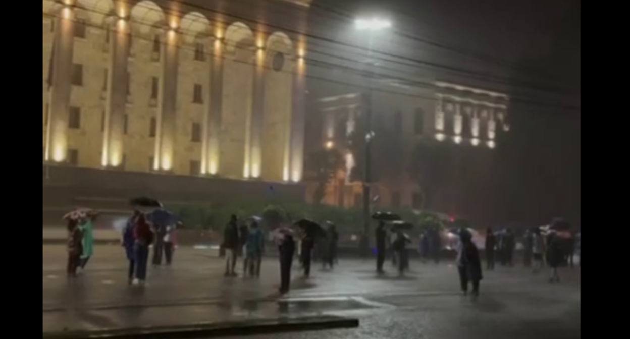 Активисты под зонтиками у парламента Грузии. Стоп-кадр видео Lorena Beria? https://t.me/Tbilisi_life/41897